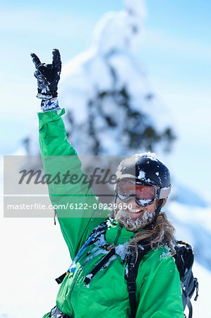 Skier making hand gesture in snow