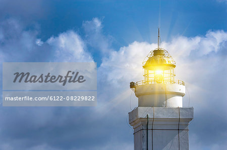 Lighthouse shining against blue sky
