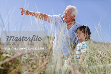 Older man and grandson standing outdoors