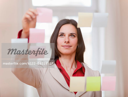 Businesswoman hanging up sticky notes