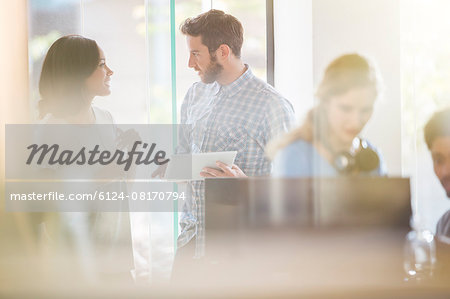 Business people with digital tablet talking in office Business people with digital tablet talking in office