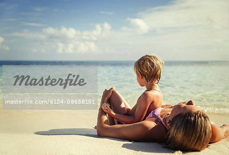 Mother and son laying and relaxing on tropical beach