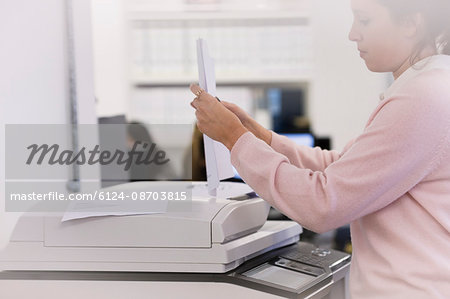 Businesswoman making copies at photocopier in office