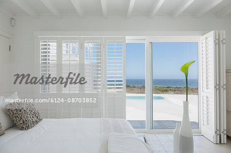 White bedroom home showcase open to swimming pool and ocean view