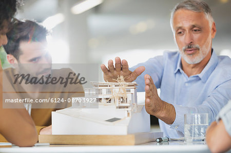 Architects discussing model in meeting