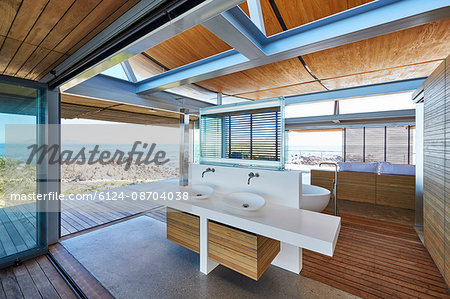 Modern luxury home showcase bathroom open to patio with ocean view