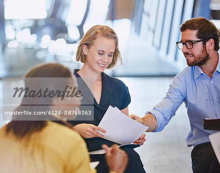 Business people discussing paperwork in meeting Business people discussing paperwork in meeting