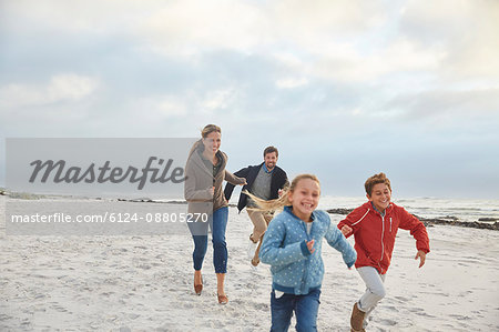 Playful family running on winter beach