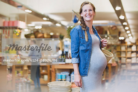 Smiling pregnant woman shopping in shop