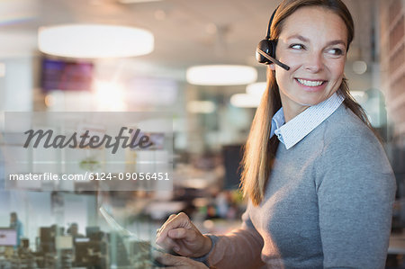 Smiling businesswoman with headset working in office