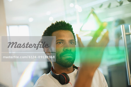 Innovative male entrepreneur examining glass cube prototype