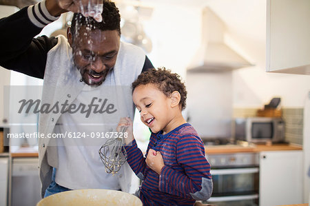 Playful father and son baking in kitchen Playful father and son baking in kitchen