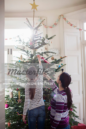 Mother and daughter decorating Christmas tree