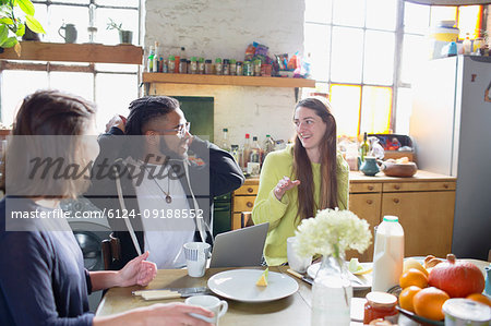 Young college student roommate friends studying at breakfast table
