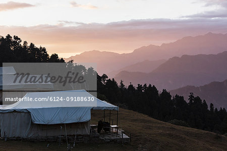 Yurts overlooking silhouetted mountains, Jaikuni, Indian Himalayan Foothills