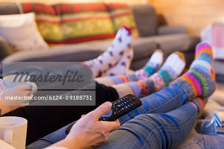 Family in colorful socks relaxing, watching TV in living room