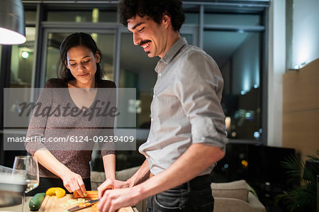 Couple cutting vegetables, cooking dinner in apartment kitchen
