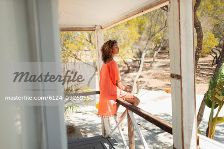 Serene young woman relaxing on beach hut patio