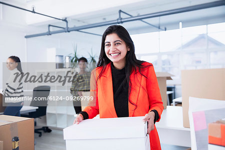 Portrait confident businesswoman moving into new office