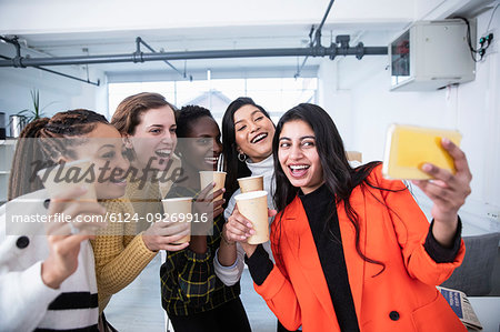 Happy businesswomen celebrating, taking selfie