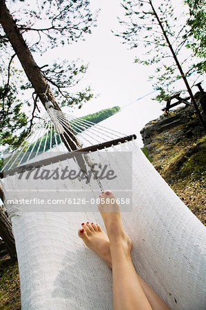 Sweden, Dalarna, Mid adult woman relaxing in hammock
