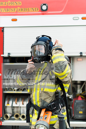 Sweden, Female firefighter putting on protective mask