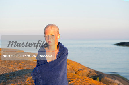 Sweden, Sodermanland, Stockholm Archipelago, Varmdo, Portrait of boy (12-13) wrapped in towel on beach