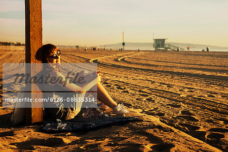 USA, California, Los Angeles, Santa Monica, Mid adult woman sitting on beach