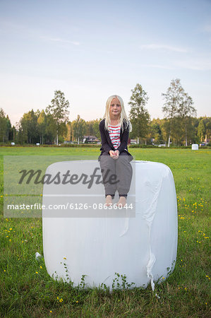 Sweden, Narke, Kilsbergen, Girl (10-11) sitting on hay bale