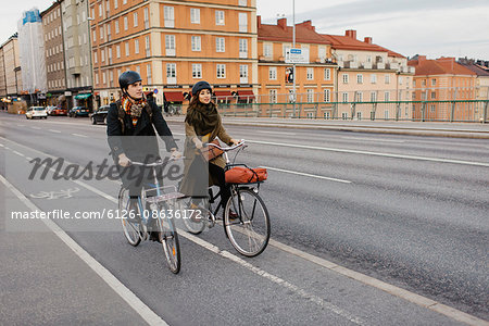 Sweden, Uppland, Stockholm, Vasatan, Sankt Eriksgatan, Man and woman cycling on city street