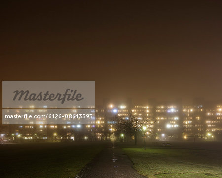 Sweden, Skane, Malmo, Rosengard, Illuminated residential buildings in fog