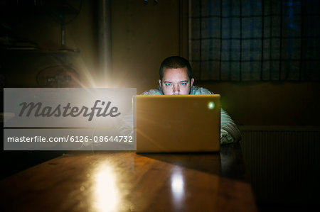 Finland, Man sitting at table and using laptop