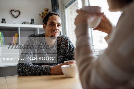 Sweden, Young couple sitting at table and drinking coffee