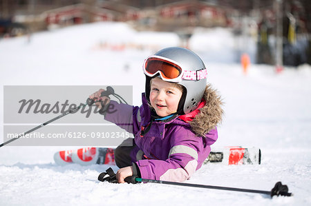 A young girl fallen off her skis