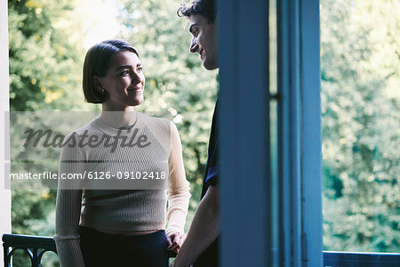Young couple standing on balcony