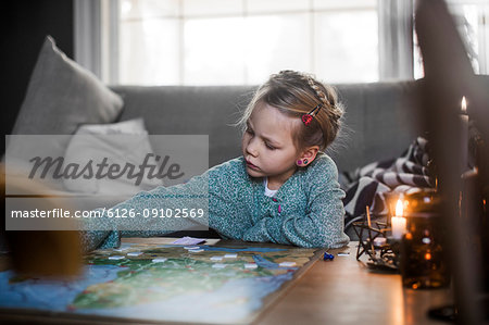 Girl playing board game on coffee table