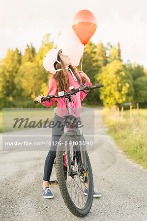 Girl riding bicycle at sunset