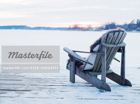 Wooden chair on deck in snow in Sigtuna, Sweden