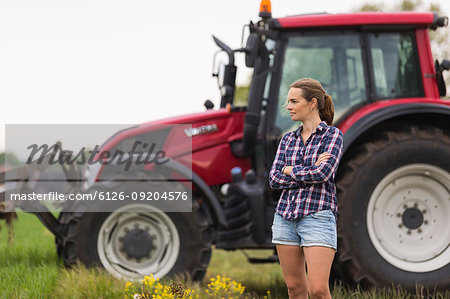 Agricultural worker standing in front of tractor