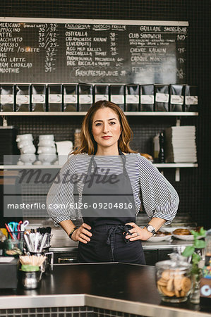 Portrait of barista behind counter in cafe