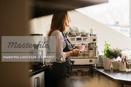 Barista holding coffee in cafe kitchen