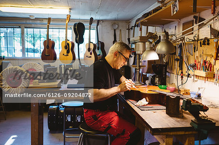 Craftsman working in guitar making workshop