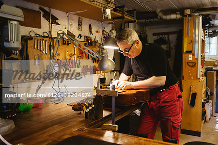 Craftsman working in guitar making workshop