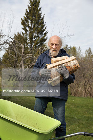 Senior man collecting firewood