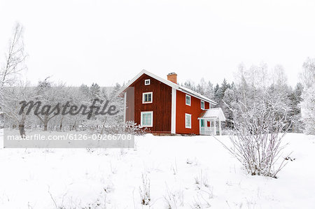 Red farmhouse in snow