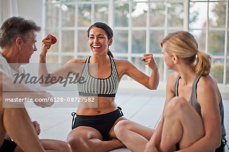 Group of people doing sun salutations during a yoga class.