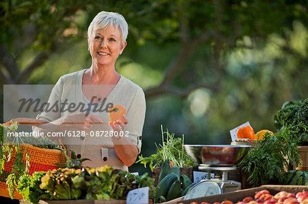 Mature woman shopping for fresh vegetables at a farmer's market.
