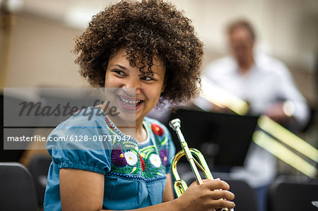 Teenage girl learning to play trumpet.