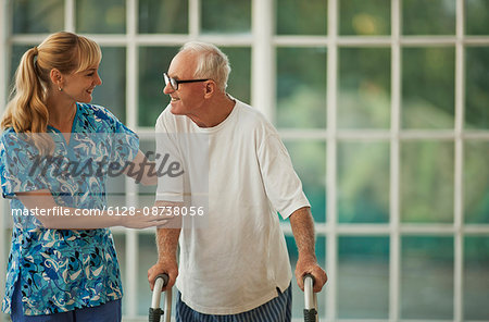Happy young nurse comforting a senior man.