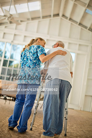 Happy young nurse comforting a senior man.